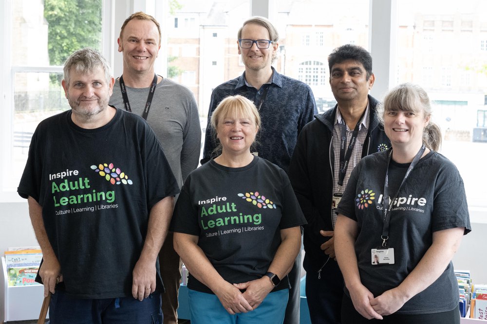 A group of Inspire Learning tutors standing together and posing for a group photo