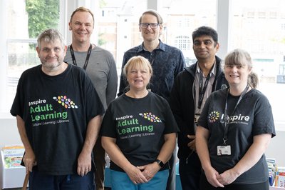 A group of Inspire Learning tutors standing together and posing for a group photo