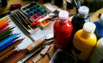 A variety of art materials, paints, coloured pencils and paint pallette
