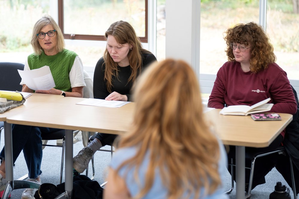 Three people taking part in a writing workshop