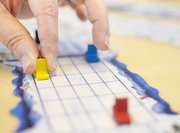 hands moving a counter on a game board