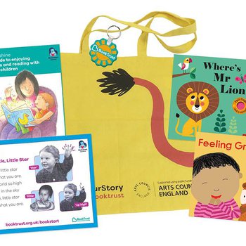 Bright yellow long handled bag with tiger's tail printed on it surrounded by 2 board books for babies and information leaflet.