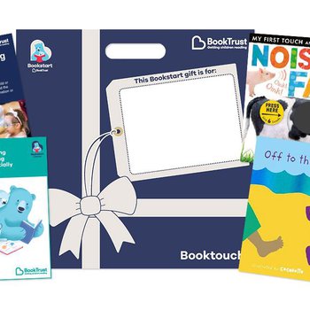 Dark blue square envelope with white ribbon and bow printed on it alongside 2 baby board books and informational leaflets.