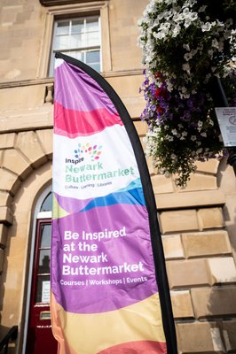 a colourful feather shaped flag, that says Inspire Newark Buttermarket