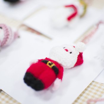 Handmade crochet figures of Santa and snowmen, backed onto card to look like pin badges
