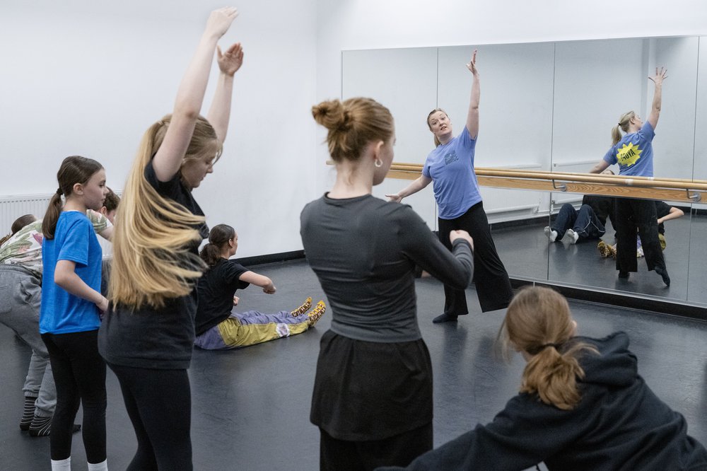 A group of young people dancing in front of a mirror