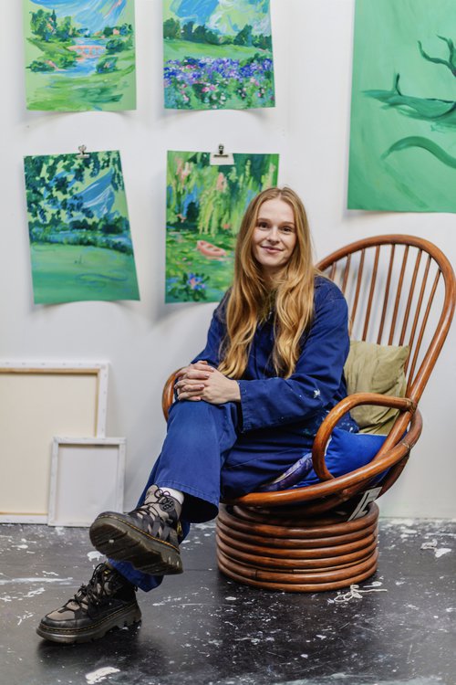 A woman wearing a blue outfit sat on a brown chair.