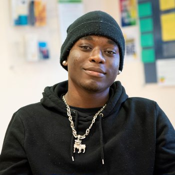 A young male Inspire College student looking and smiling into the camera.
