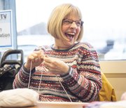 woman knitting and looking to the side laughing