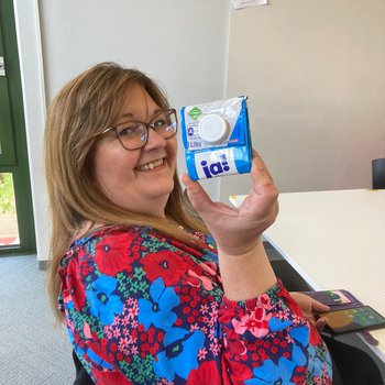 Staff member with a wallet they made out of a milk carton.