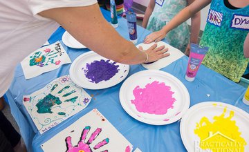 adults and children using hands to make hand print paintings