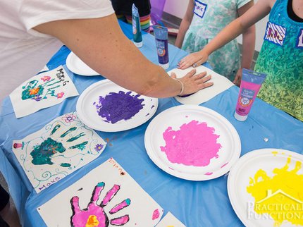 adults and children using hands to make hand print paintings