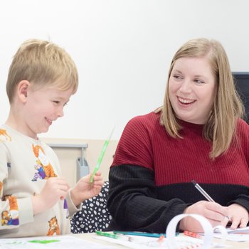 Child and parent doing a craft activity, laughing