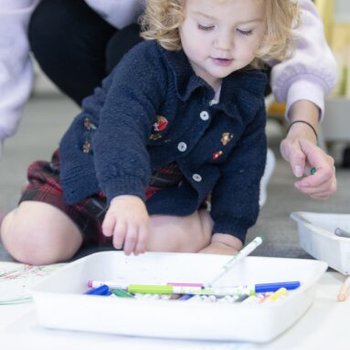 Young girl sitting on the floor drawing