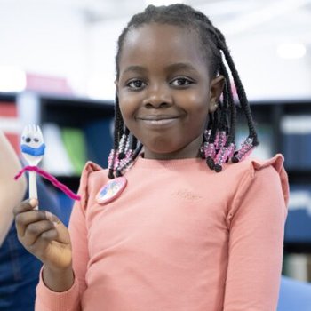 Girl smiling and holding up a Forky