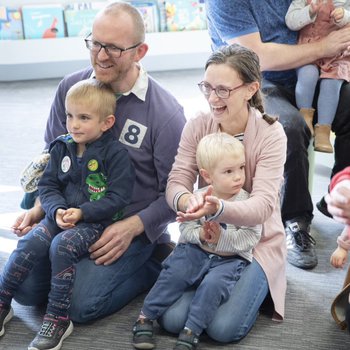 Children sitting on parents laps smiling and laughing