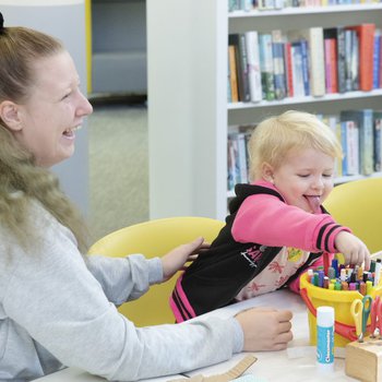 Mother and baby, smiling and laughing, playing with toys