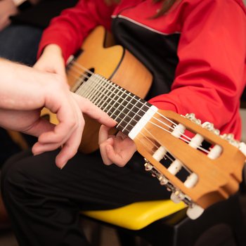 A child holding an acoustic guitar