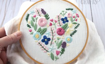 an embroidery hoop with embroidered flowers in the shape of a heart