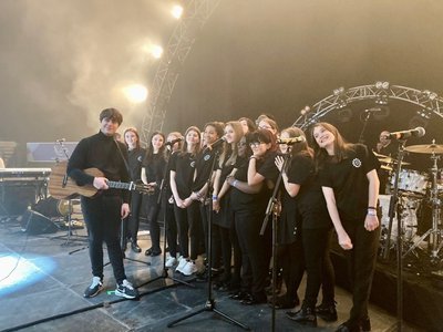 Queen Elizabeth's school choir performing on stage at the Nottingham Arena with Jake Bugg in November 2022