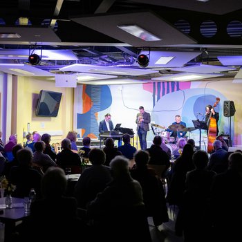 Jazz musicians onstage in the library with audience in foreground