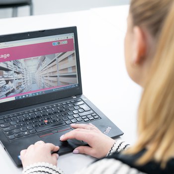 The back of a person's head browsing the Inspire website on a laptop