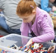 young girl picking logo out a plastic container