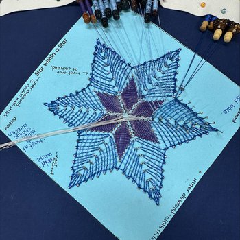 A bobbin lace pattern in progress.
