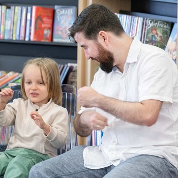 Young girl and father taking part in music session in the library