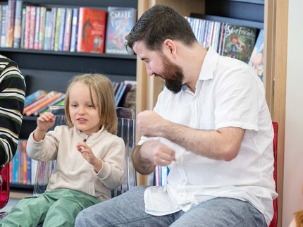 Young girl and father taking part in music session in the library