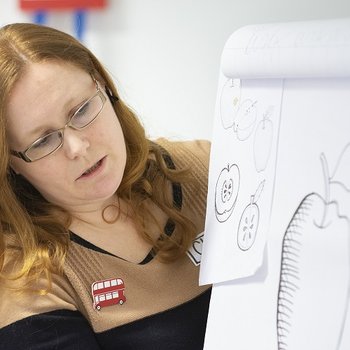 A lady labelling an illustration of a fish
