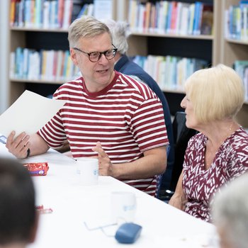 Peter Snelling from MyPockets leading a workshop. He sits next to a woman talking.