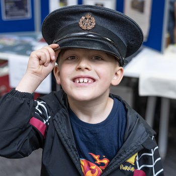 Child wearing a flat cap smiling at the camera