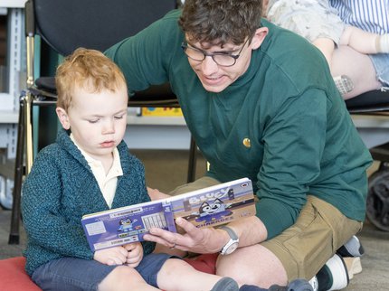 A father and baby read a book together