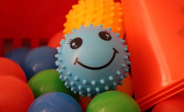 sensory toys, an assortment of balls including a blue spikey one with a smiley face
