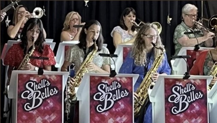 Photograph of the seven members of Shell's Belles with tumpets, trombones and saxophones
