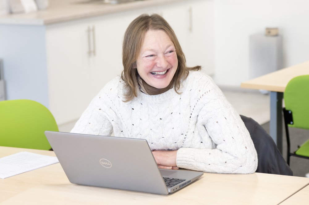 Smiling female learner with a laptop