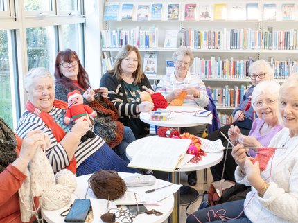Group of people sat knitting at a library Knit and Natter event