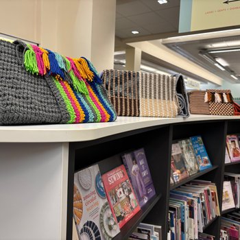 Folded scarves on top of the library shelves