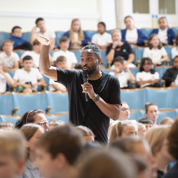 Music teacher conducts an audience of children